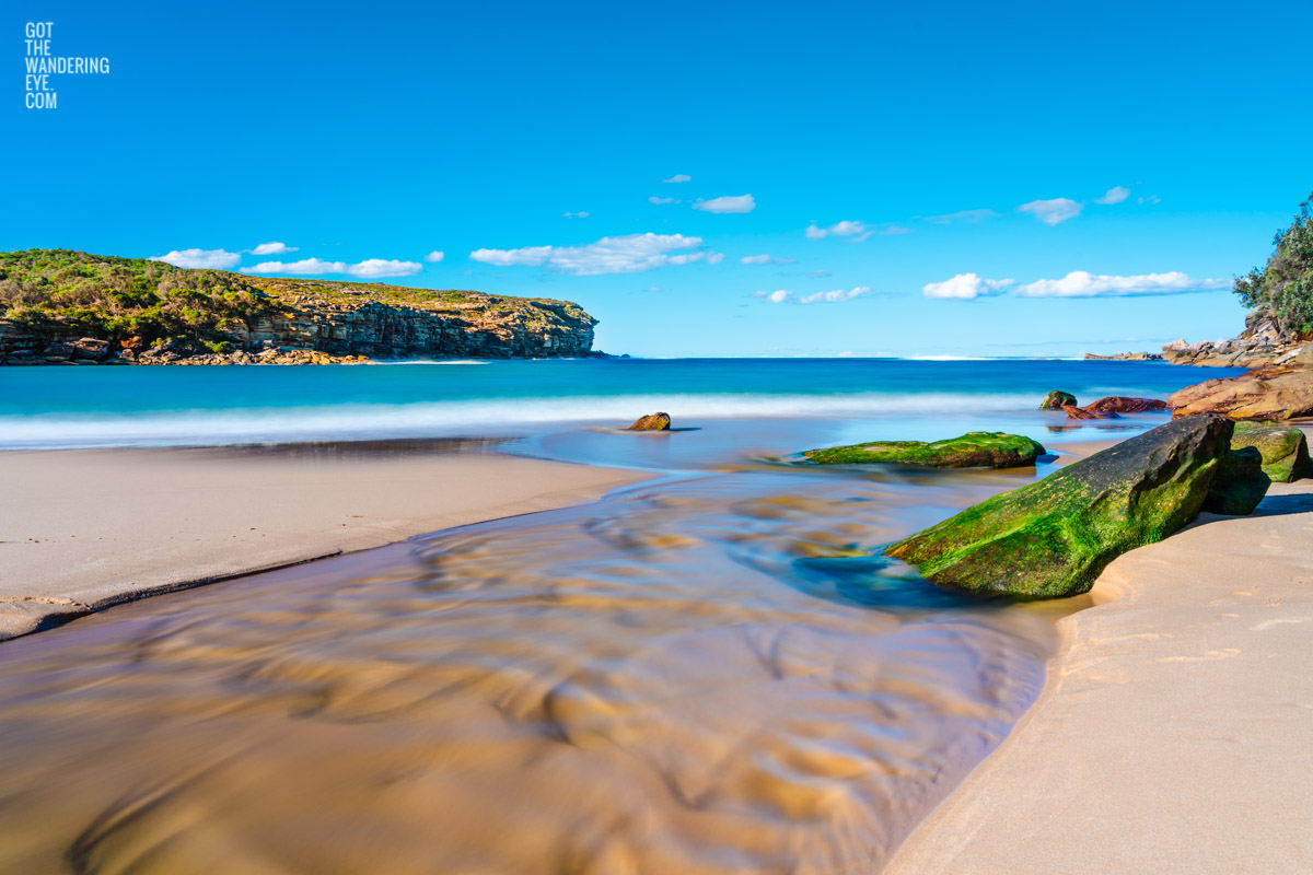 Beautiful long exposure photography of Wattamolla Beach, with waterfall stream flowing into beach, ocean. Royal National Park