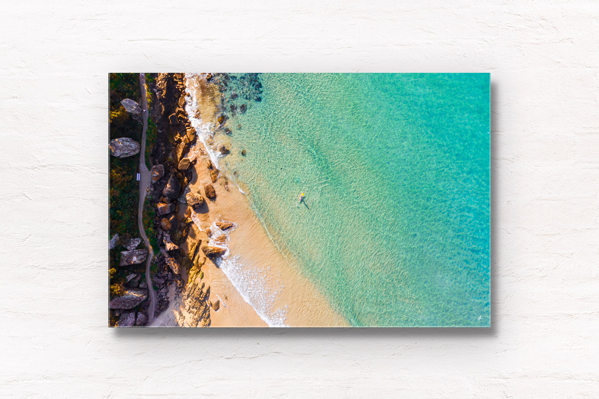 Buy fine art framed prints of a aerial seascape above Freshwater Beach of a man on paddleboard enjoying the crystal clear ocean.
