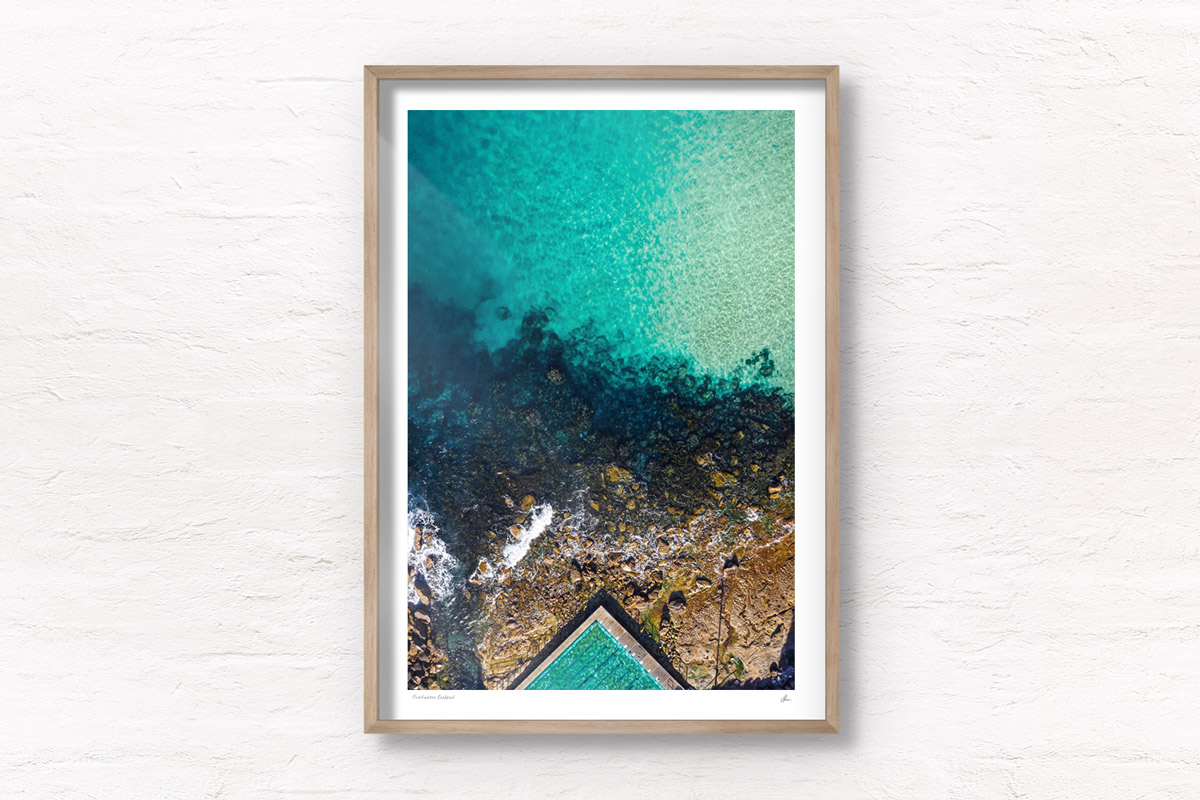 Fine art framed print of a aerial oceanscape above crystal clear waters of Freshwater Beach. Ocean, rockpool summertime.