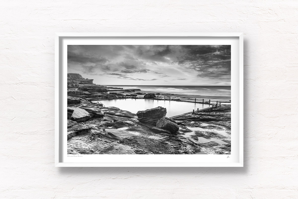 Fine art framed print of an ocean rockpool in the middle of a rocky beach edge. Mahon Pool, Maroubra on a cloudy m