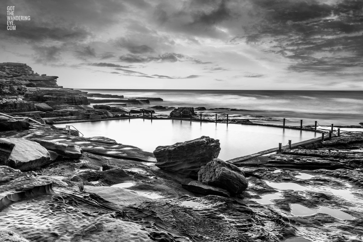 Ocean rockpool in the middle of a rocky beach edge. Mahon Pool, Maroubra on a cloudy moody day. Mahon Pool Long Exposure