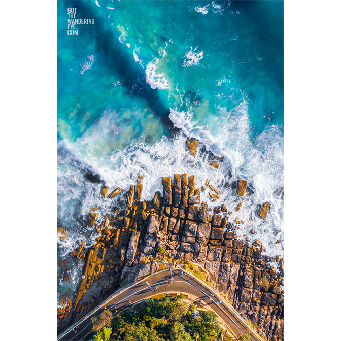 Aerial oceanscape above Marine Parade in Manly. Waves, ocean, beach rocks, walking path