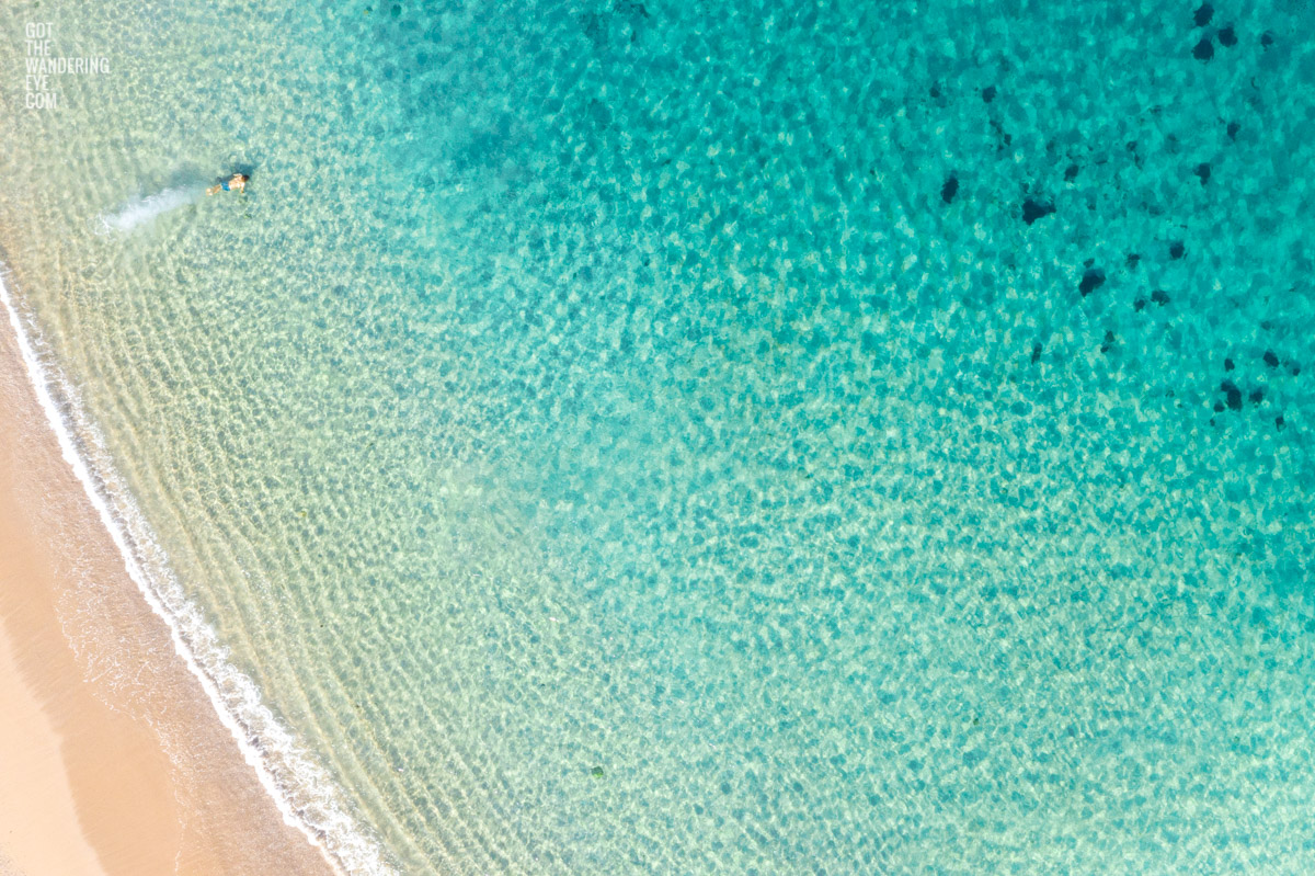 Swimming Shelly Beach Manly. Aerial oceanscape above turquoise clear waters of a man diving into Shelly Beach, Manly.