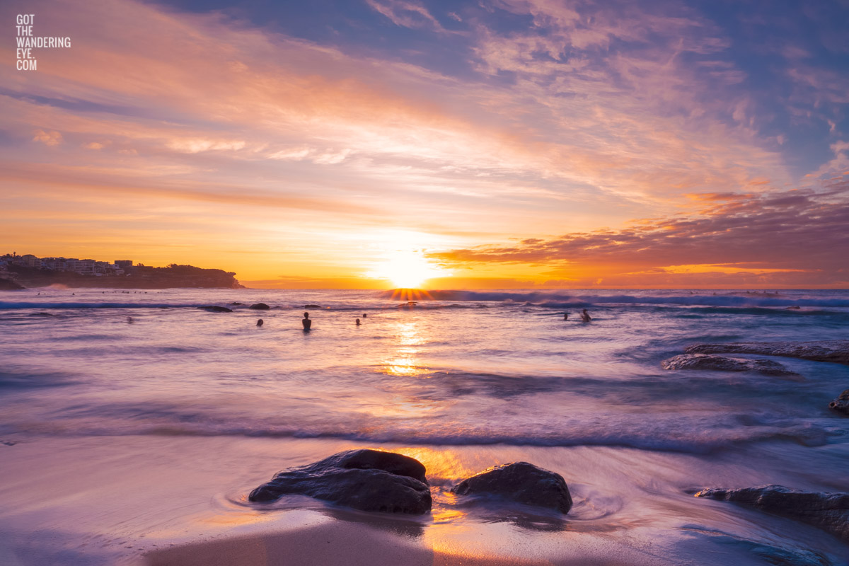 Swimmers enjoying a beautiful sunrise with whispy clouds over Bronte Beach, Sydney by Allan Chan