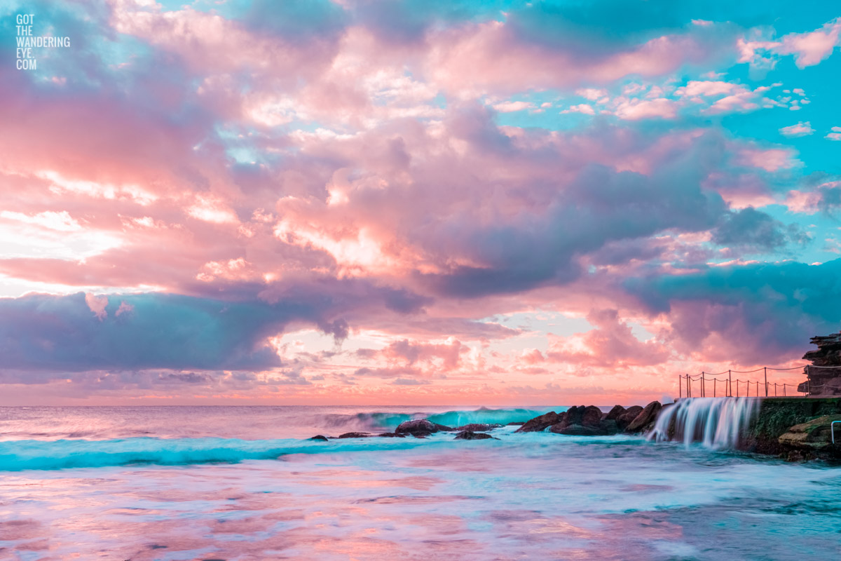 Puffy cotton candy coloured clouds during sunrise at Bronte baths Rockpool.