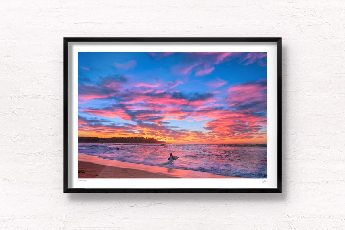 Surfer watching a stunning pink puffy cloud sunrise over beautiful Bondi Beach by Allan Chan