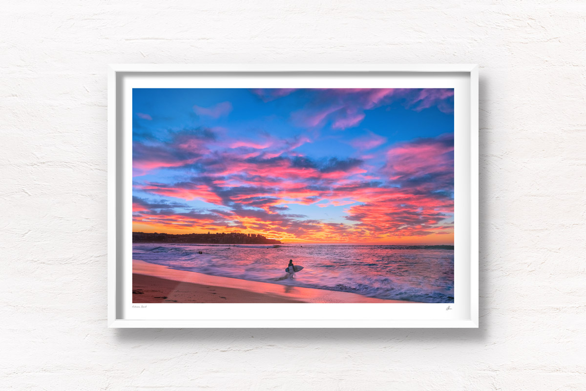 Surfer watching a stunning pink puffy cloud sunrise over beautiful Bondi Beach by Allan Chan
