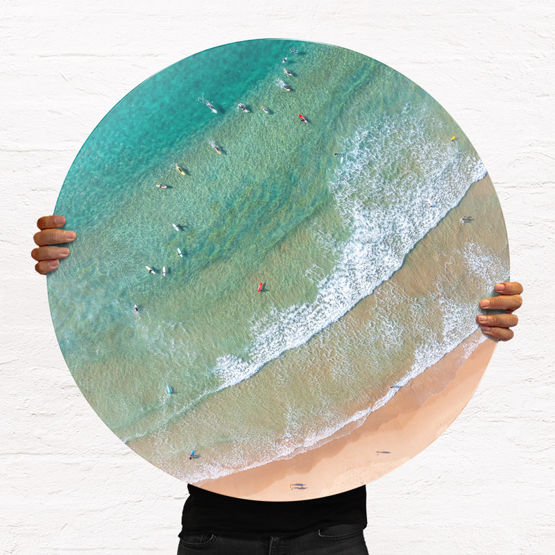 ChromaLuxe round metal print of the ocean. Aerial oceanscape above surfers in the lineup at Freshwater Beach. Wall art delivered and ready to hang.