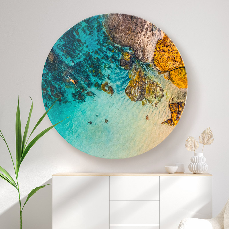 ChromaLuxe round metal wall art ocean prints. Aerial oceanscape above a woman swimming alone inside the Bogey Hole at Bronte Beach. Wall art delivered and ready to hang.