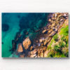 Framed wall art acrylic of Man Swimming in clear emerald waters of Gordons Bay, surrounded by palm trees and boulders from the clifftop.