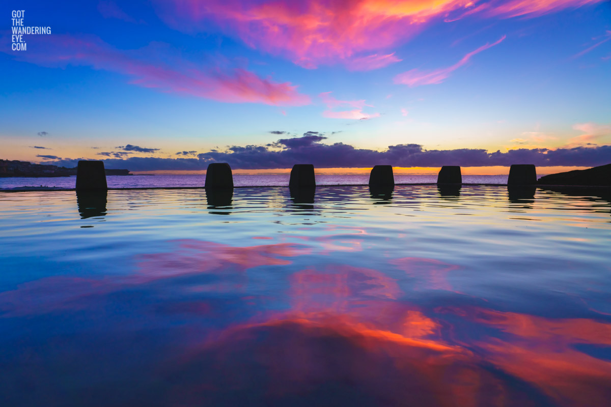 Incredible pink whispy cloud sunrise over glistening pink and blue waters Coogee at the Ross Jones Memorial Pool.