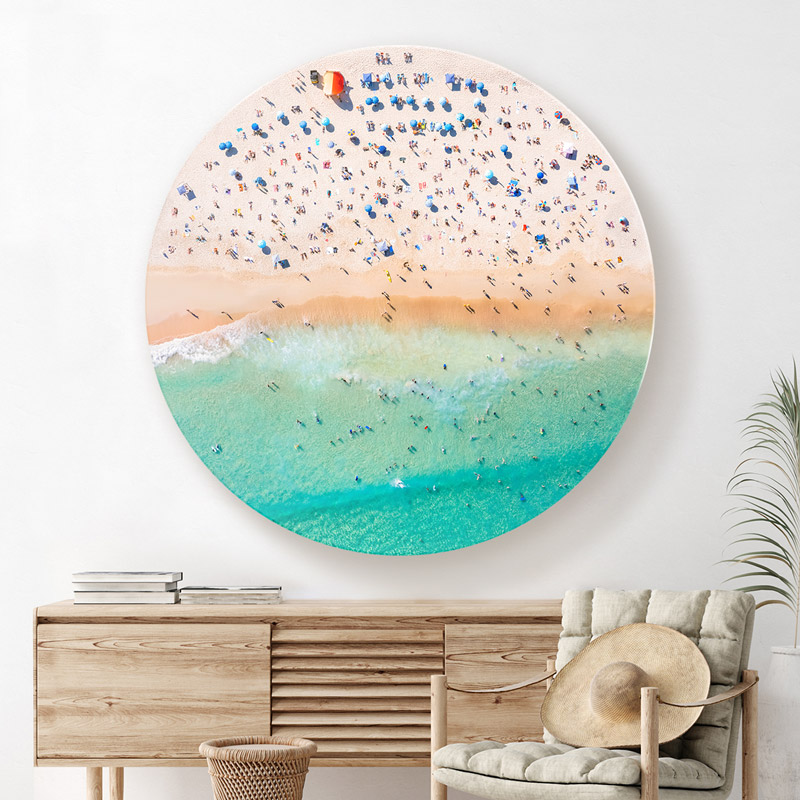 ChromaLuxe round metal wall art ocean prints. Aerial oceanscape above a packed Bondi Beach with blue beach umbrellas. Centrepiece artwork for the home. Wall art delivered and ready to hang.