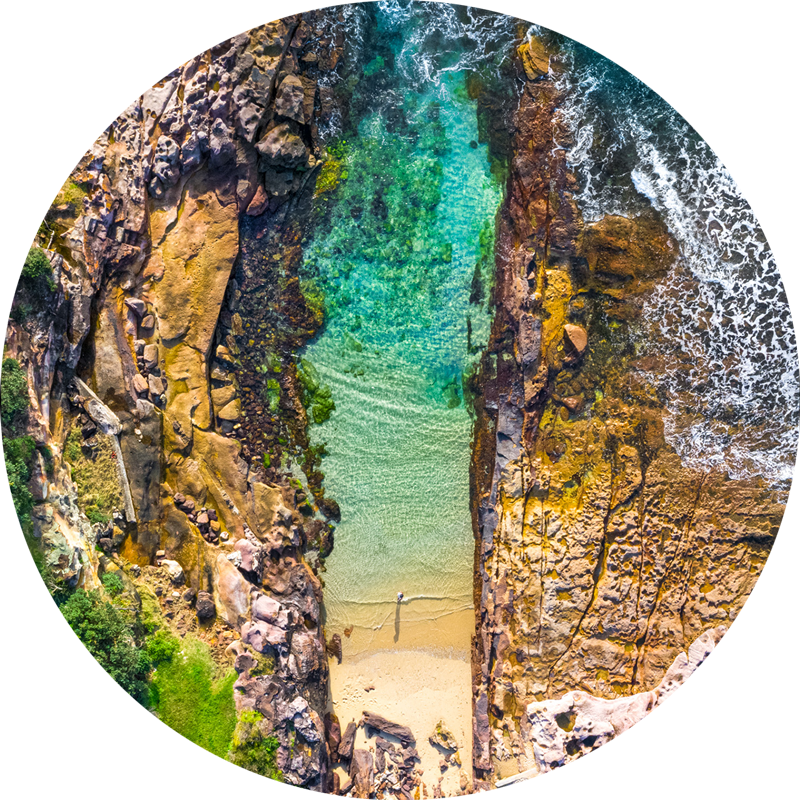 Ocean Aerial Cronulla. ChromaLuxe round metal print of the ocean. Aerial oceanscape above a woman enjoying a slither of the Sutherland Shires Cronulla Beach. Wall art delivered and ready to hang.