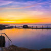Passionfruit coloured sunrise over a empty long exposure of Mahon Pool at Maroubra