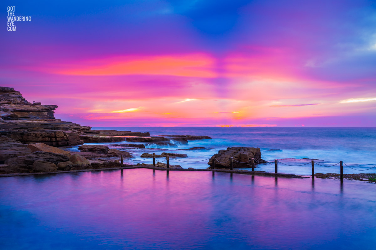 Pink and purple aurora sky, over a empty still Mahon Pool, Maroubra