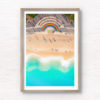 Vibrant 50 metre long rainbow on the promenade curving around the Coogee steps, as swimmers walk along the beach.
