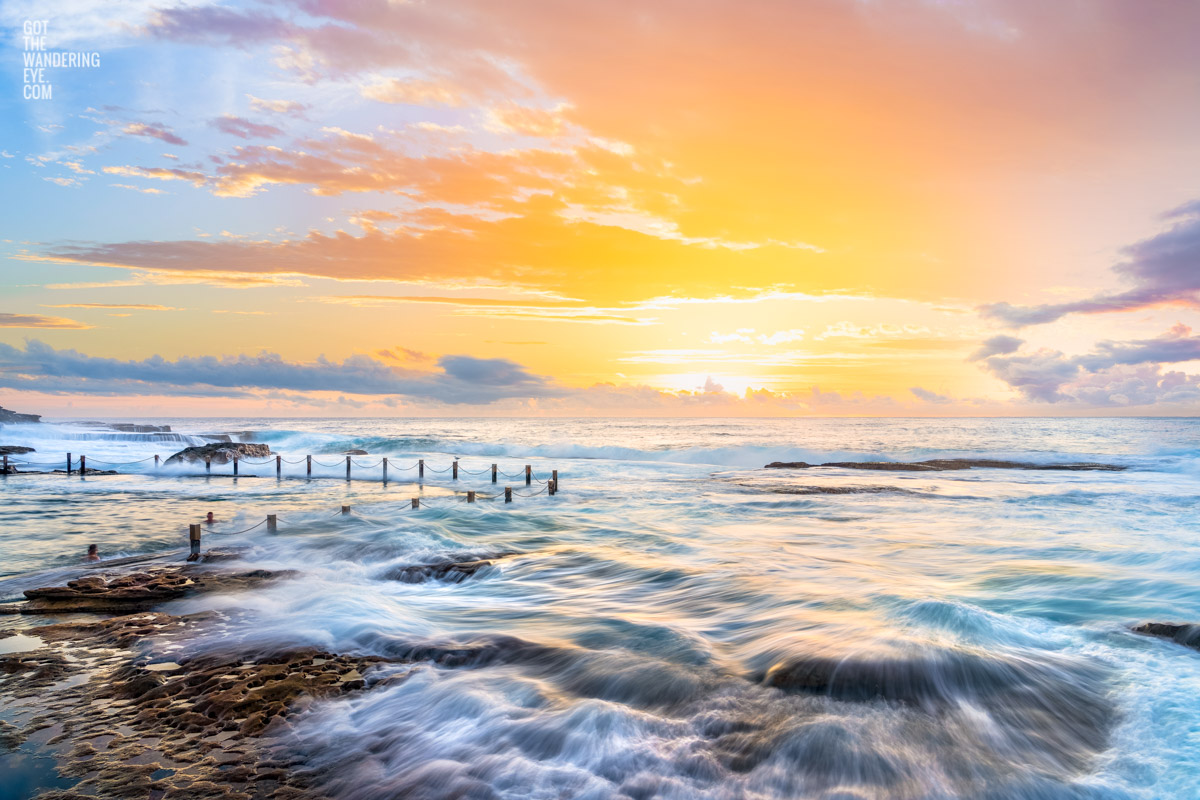 Swimmers at Mahon Pool, Maroubra soaking up the sunrise views as the tide flows over the tiny rock pools.