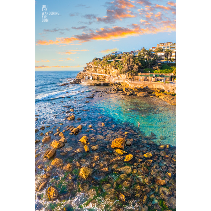 Swimmers enjoying the iconic swimming hole during golden hour in the morning at Bronte Beach Bogey hole Sydney.