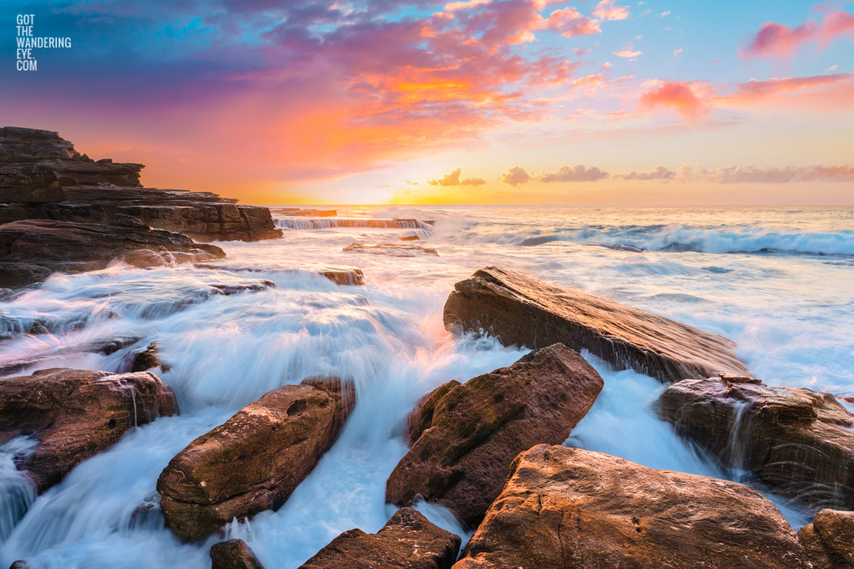 Maroubra Sunrise Landscape Photography. Beautiful long exposure of waves crashing over rocks at Mahon Pool Maroubra during an angelic sunrise.