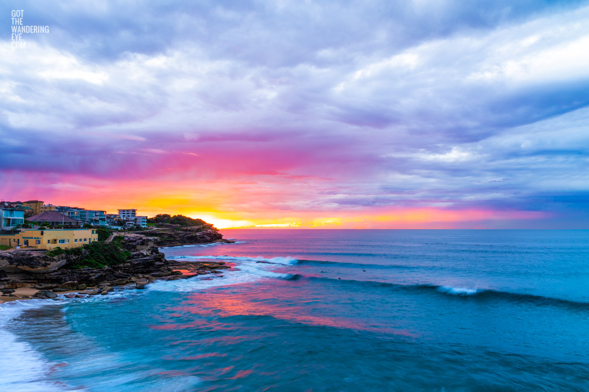 Surfing at sunrise at Tamarama Beach. Colour explosion on the horizon on a stormy wet morning in Sydneys’ Eastern Suburbs.