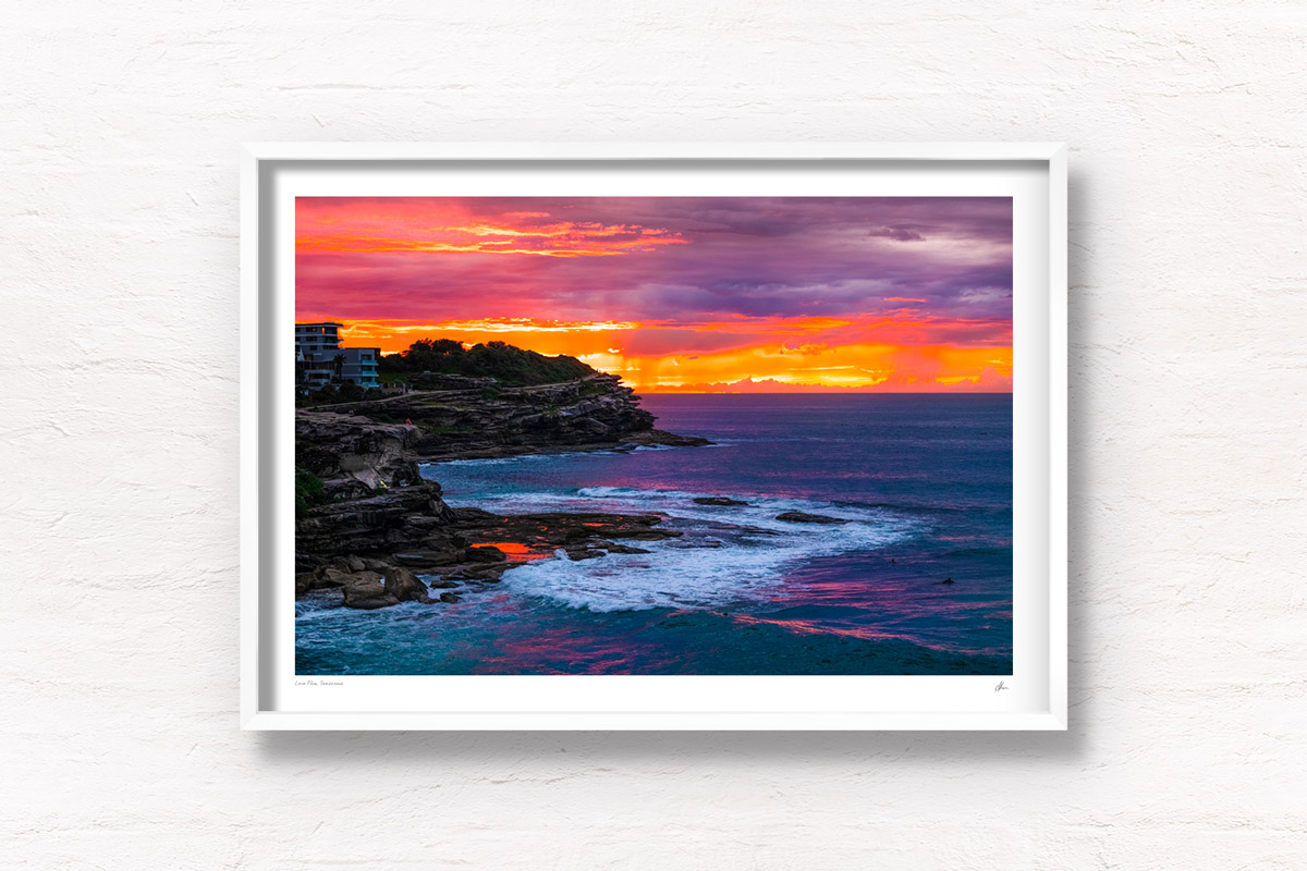 Fiery sunrise orange sky rising above MacKenzies Bay. Tamarama Sunrise of the coastal walk, Sydney.