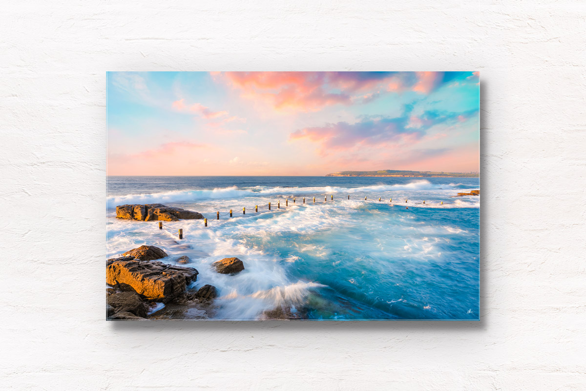 Mahon Pool Maroubra in Sydney getting smashed with waves on a dreamy sunset pink sky.