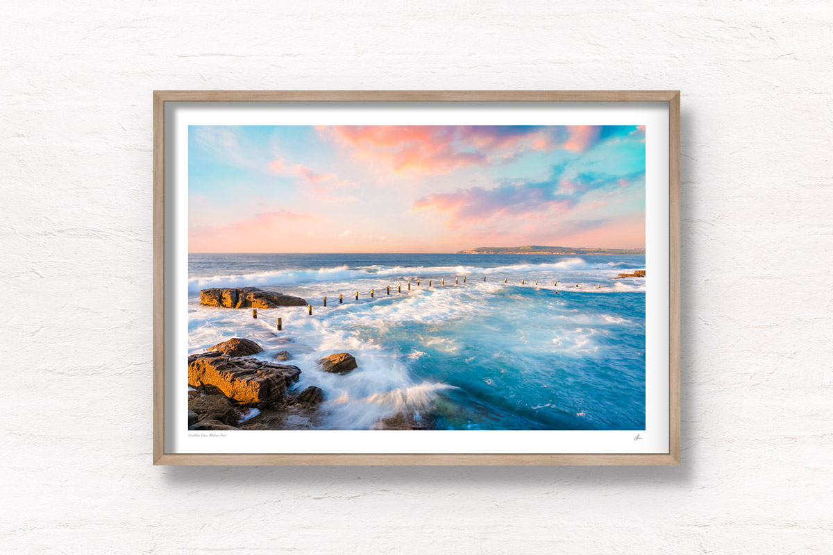 Mahon Pool Maroubra in Sydney getting smashed with waves on a dreamy sunset pink sky.