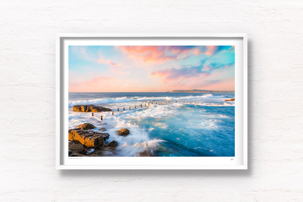 Mahon Pool Maroubra in Sydney getting smashed with waves on a dreamy sunset pink sky.