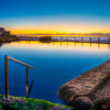 Sunrise at Sydney's Best Ocean Pool. Reflections on an empty still rock pool at Mahon Pool Maroubra by Allan Chan.