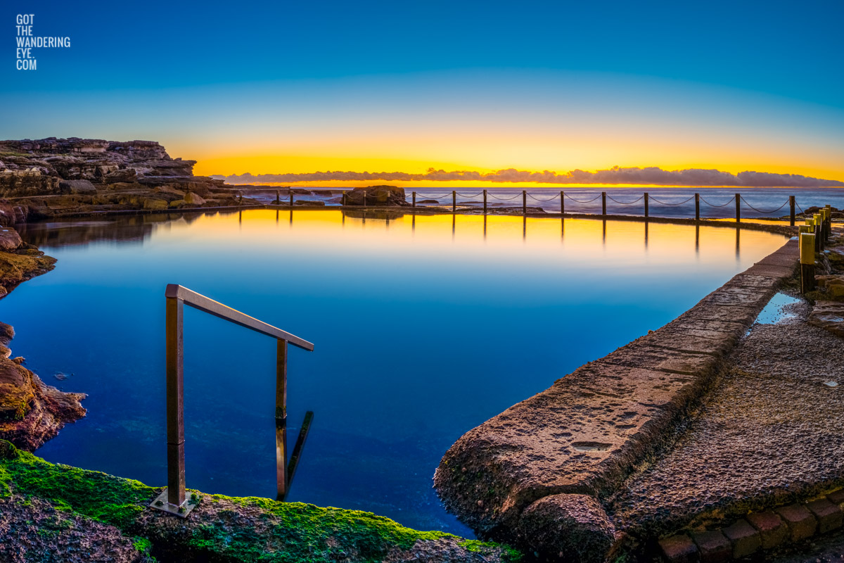 Sunrise at Sydney's Best Ocean Pool. Reflections on an empty still rock pool at Mahon Pool Maroubra by Allan Chan.