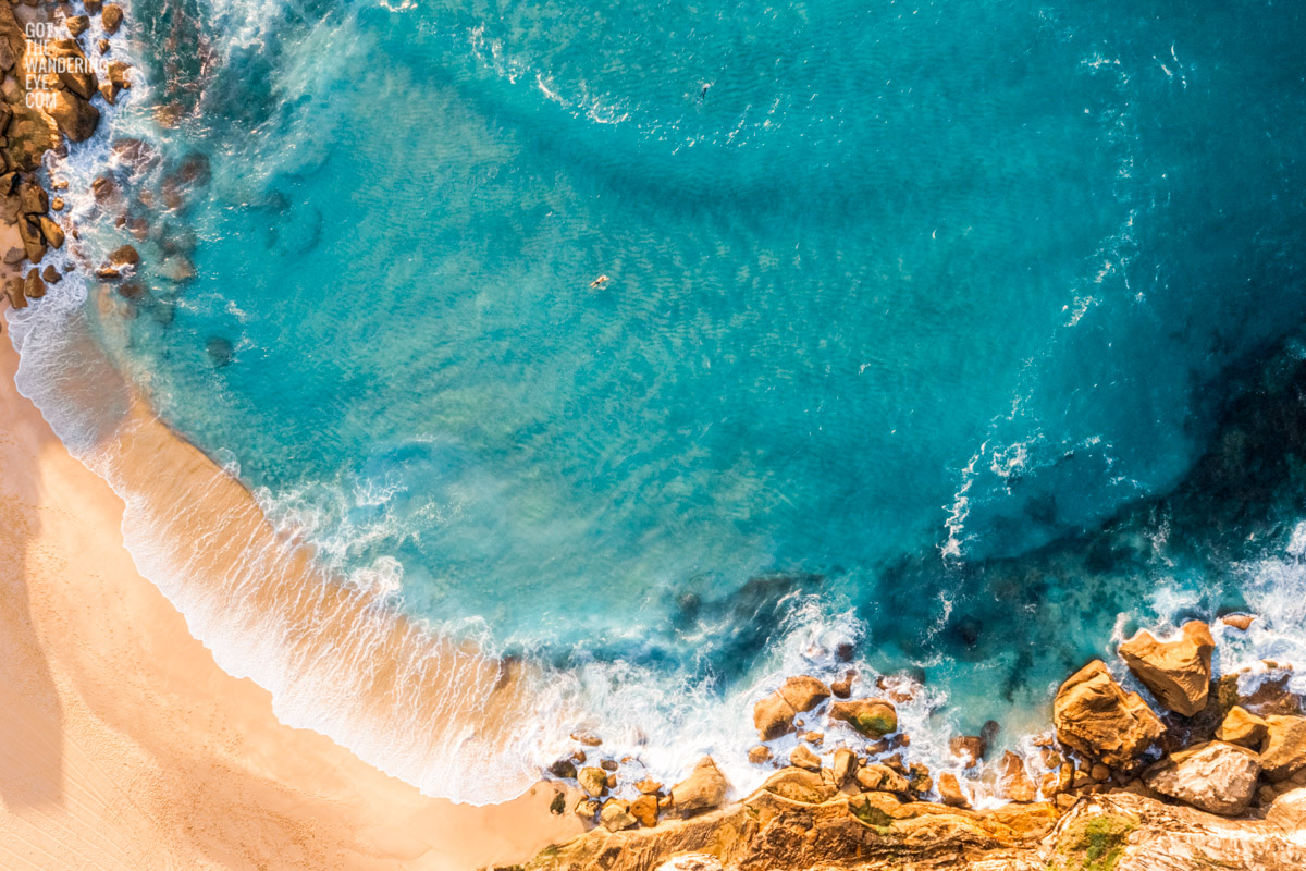 Surfing Tamarama Beach. Aerial view above surfers paddling out on the eastern suburbs best surfing beaches in Sydney.