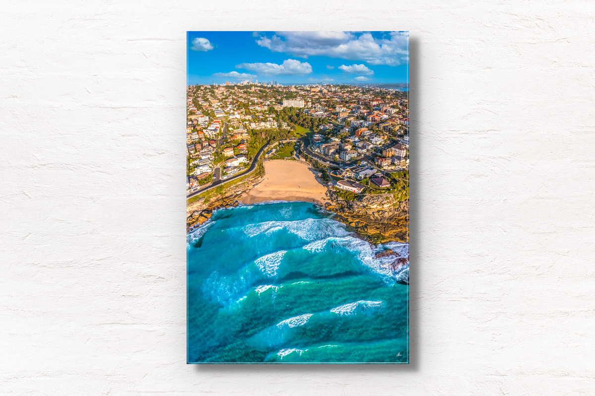 Tamarama Beach Aerial Photography. Pumping waves and the view looking back towards the Sydney City skyline on a clear blue sky day.