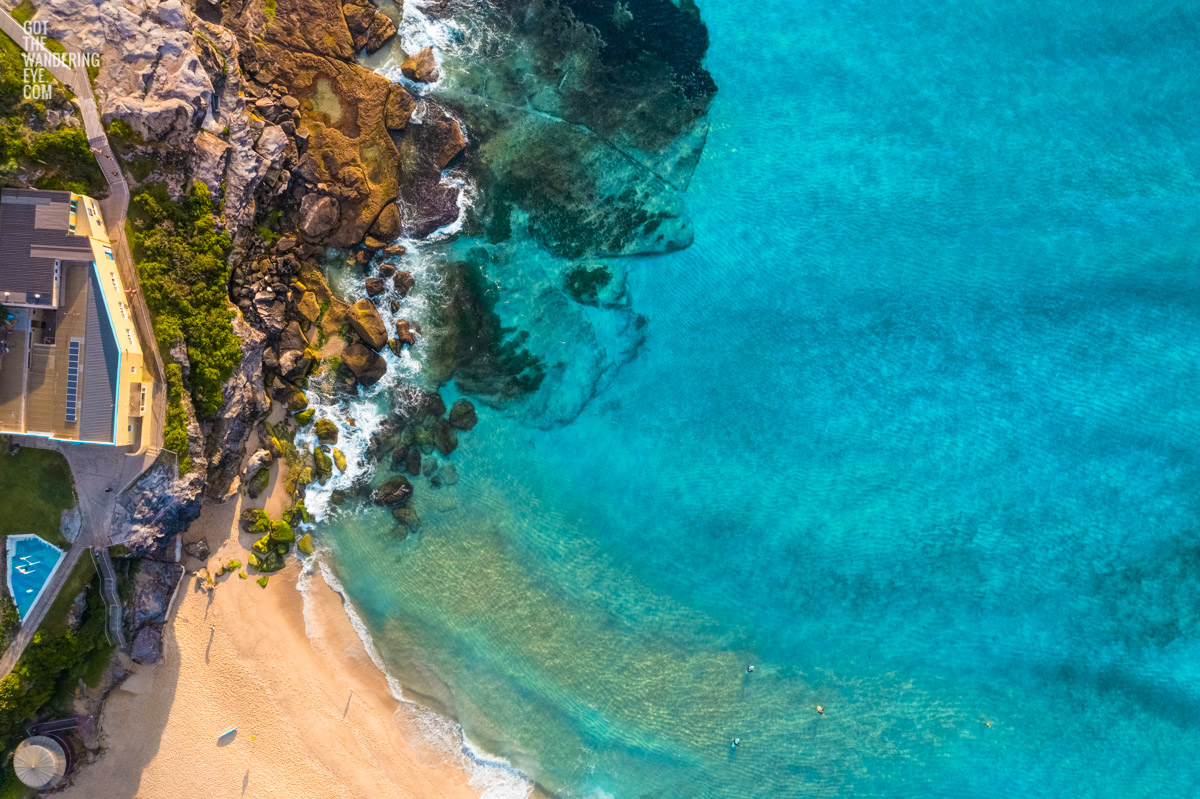 Tamarama Beach Aerial. Surfers waiting for waves. Crystal clear turquoise coloured ocean.