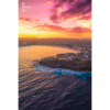 Aerial view above a Bondi Beach Sunset over the Sydney CBD skyline, glowing colour on the ocean waves.