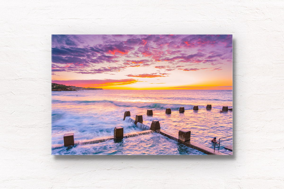 Cotton candy puffy pink clouds at a beautiful Sunrise at Coogee Beach from Ross Jones memorial ocean pool in Sydney.