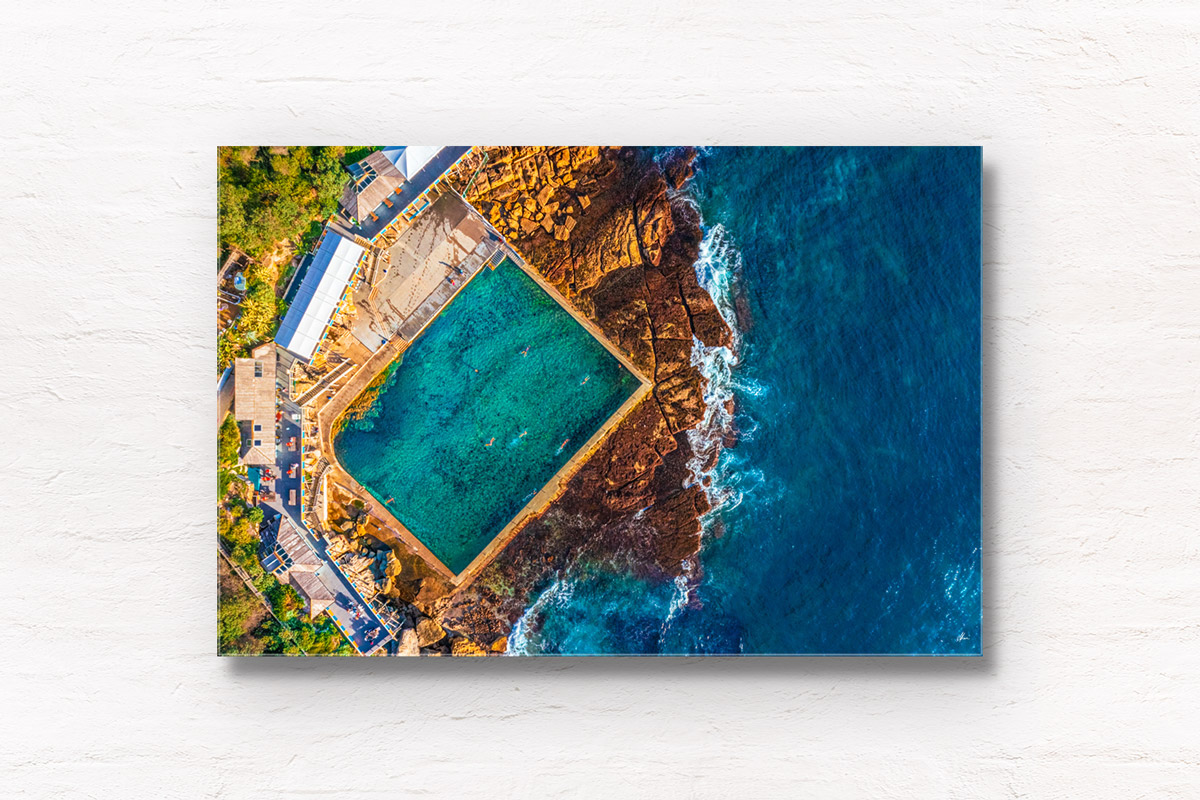 Aerial morning view above Wylies Baths Ocean Pool in Sydney. Swimmers enjoying the iconic swimming spot in Coogee.