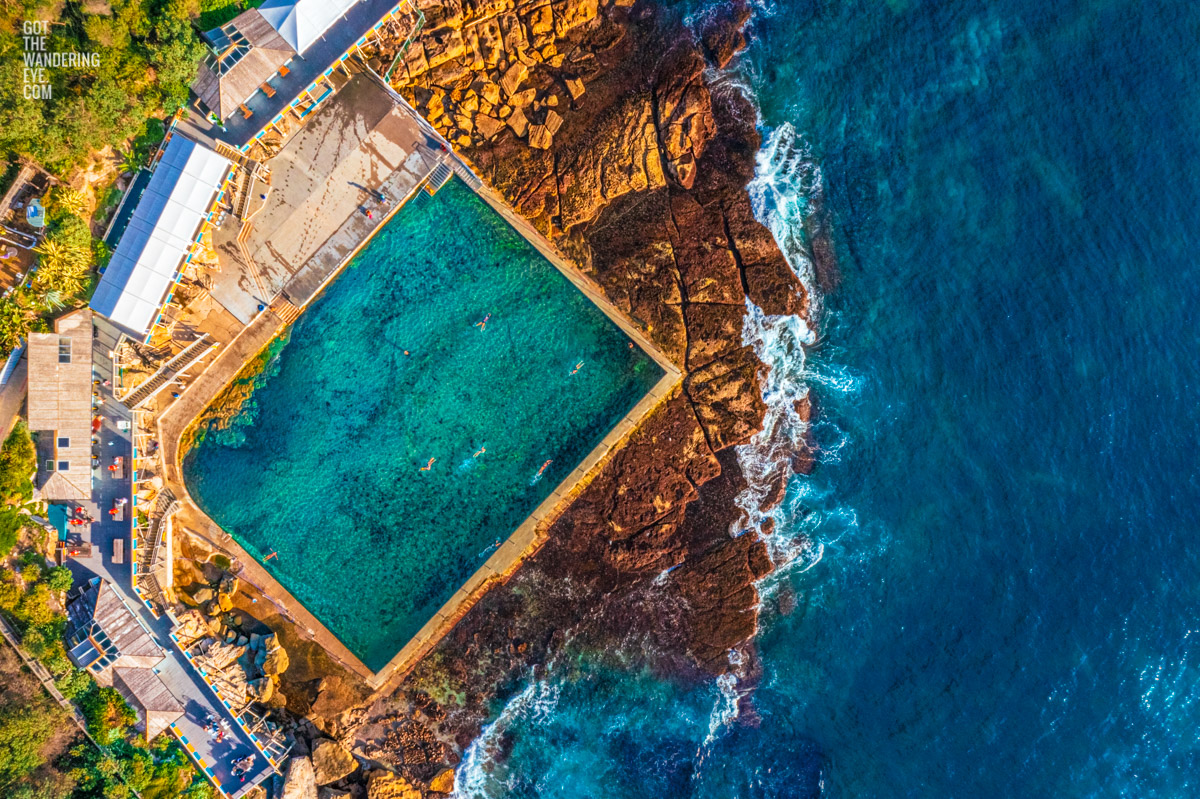 Aerial morning view above Wylies Baths Ocean Pool in Sydney. Swimmers enjoying the iconic swimming spot in Coogee.