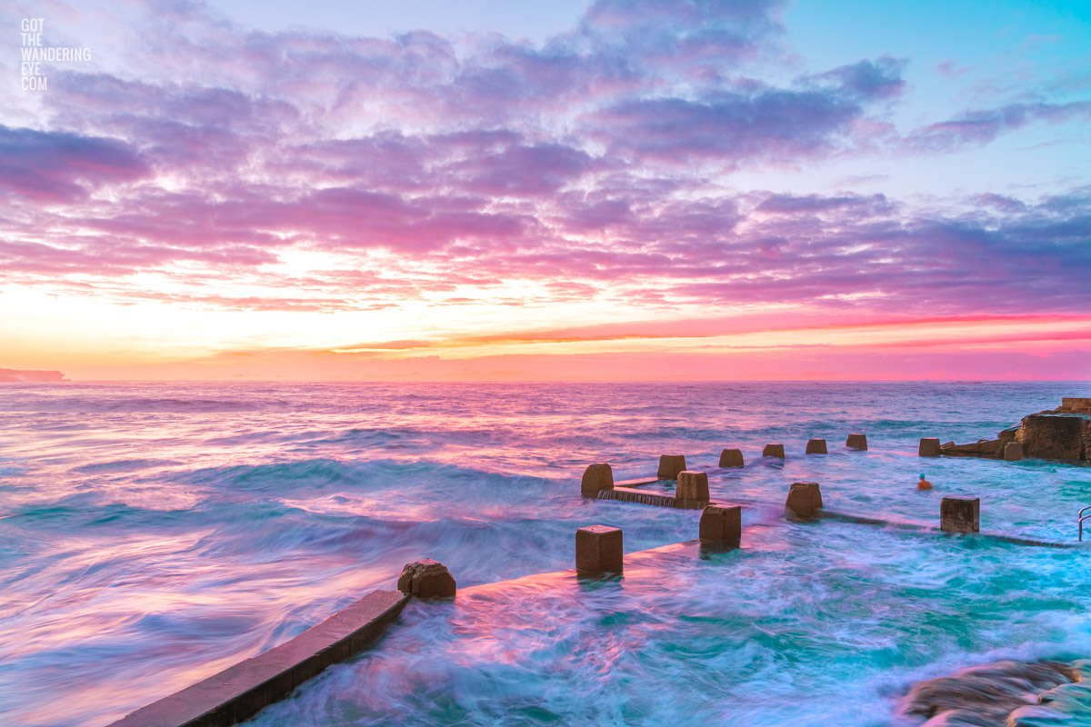 Colourful Coogee Beach Sunrise, long exposure photography of waves flowing in and over Ross Jones Memorial Rock Ocean Pool.