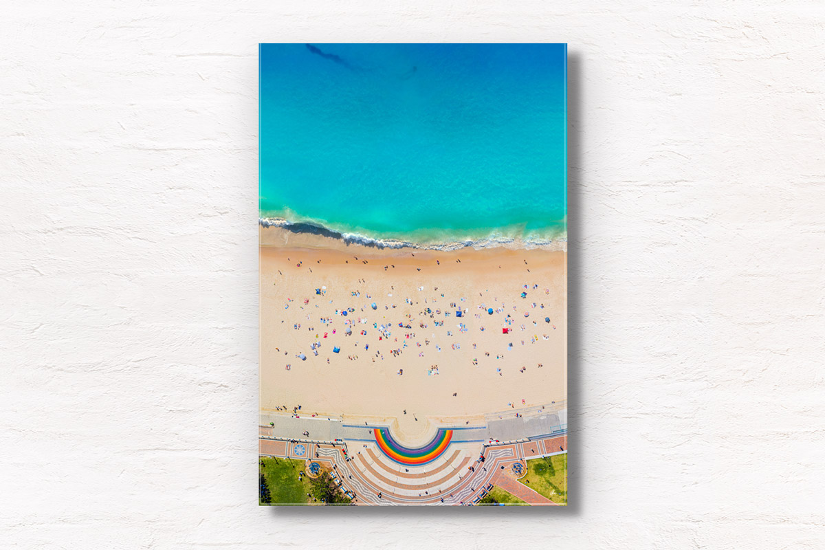 Aerial view above Coogee Beach Rainbow Walkway during a packed summers day at one of Sydney’s best beaches. Wall art print.