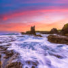 Long exposure of waves crashing over the rocks during a pink sky sunrise at Cathedral Rocks, Kiama Downs.