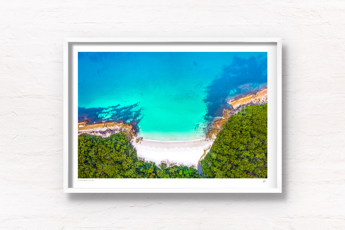 Aerial view above Greenfield Beach in Jervis Bay. The pure white sand surrounded by bushland and teal crystal water.