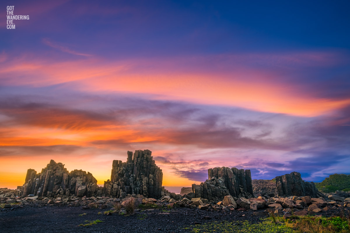 Purple orange skies illuminating the basalt columns during a sunrise at Bombo Headland Quarry Geological Site.