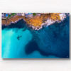 Aerial view above the blues of north Bondi Boat sheds and crystal clear ocean surrounding flat rock.