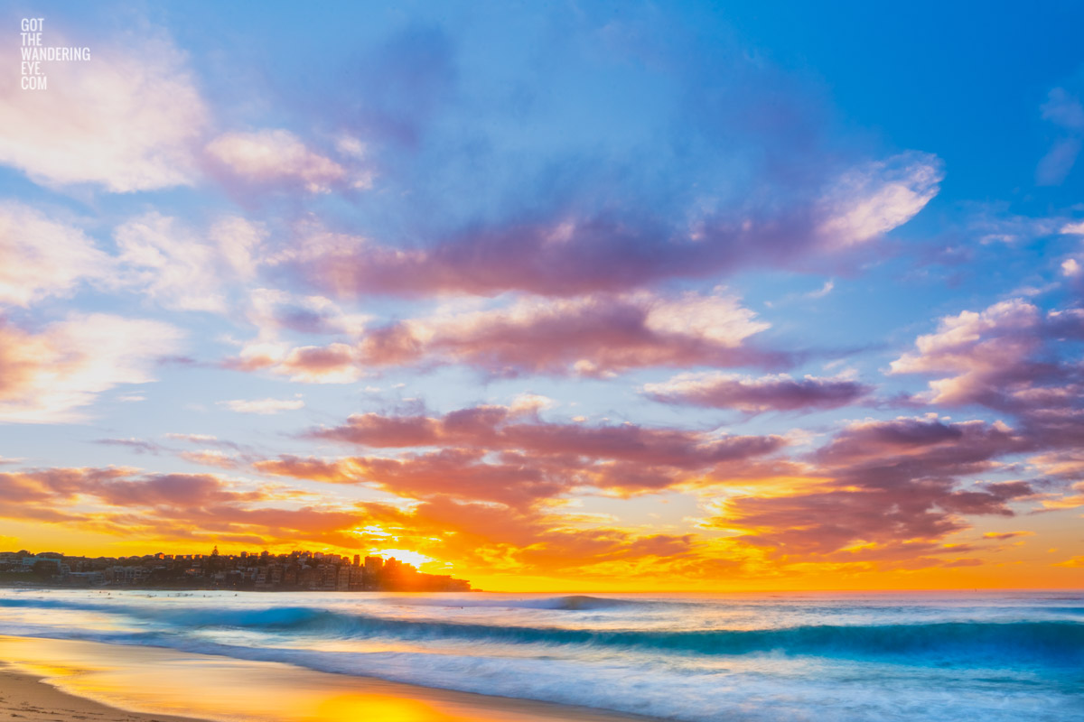 Low angle on Bondi Beach with beautiful puffy clouds with the sun poking through Ben Buckler