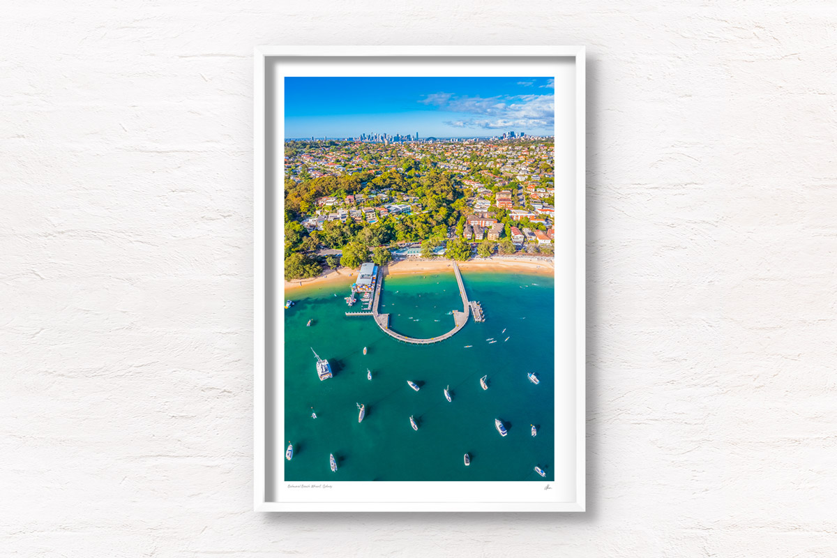 Aerial view above Balmoral Beach Wharf looking back towards the Sydney City skyline. Framed art photography wall art print.