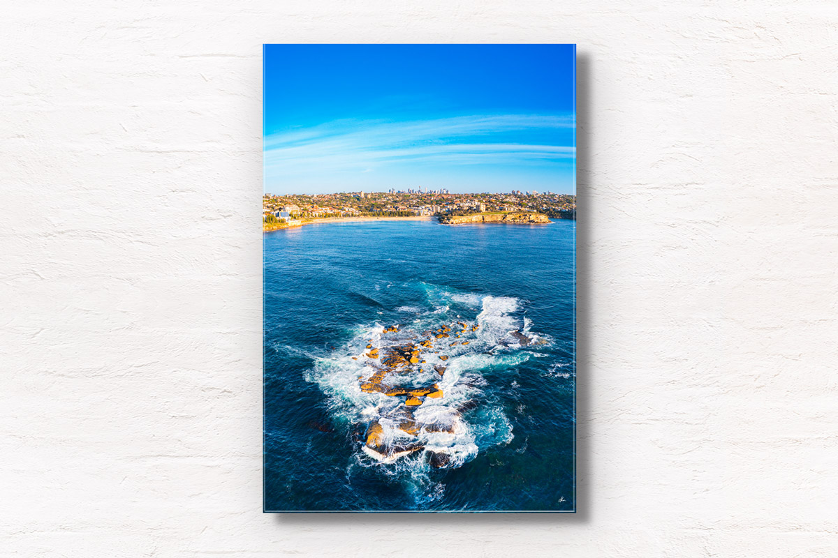 Aerial view above Wedding Cake Island looking back towards Coogee Beach on a Sunny day. Framed art photography wall art print.