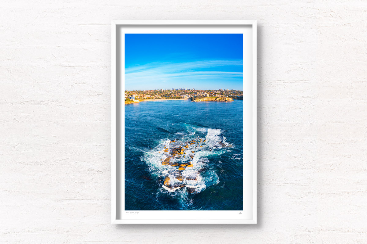 Aerial view above Wedding Cake Island looking back towards Coogee Beach on a Sunny day. Framed art photography wall art print.