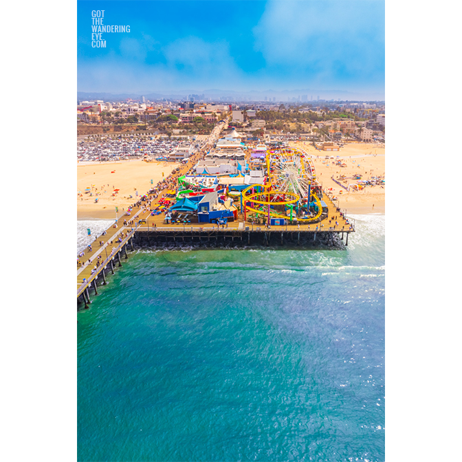 Aerial view looking back over the Santa Monica Pier on a sunny day in California.