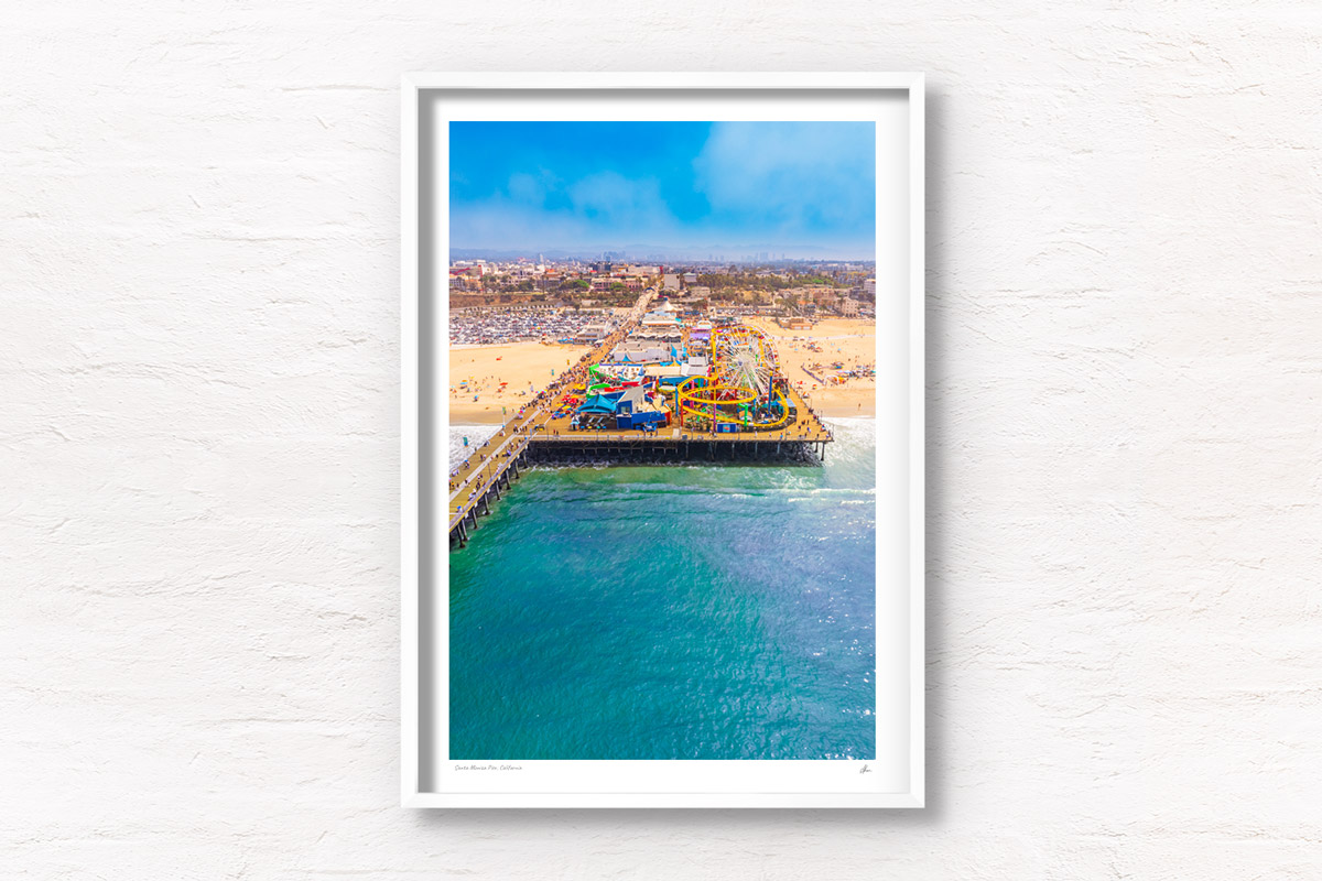 Aerial view looking back over the Santa Monica Pier on a sunny day in California. Framed art photography wall art print.