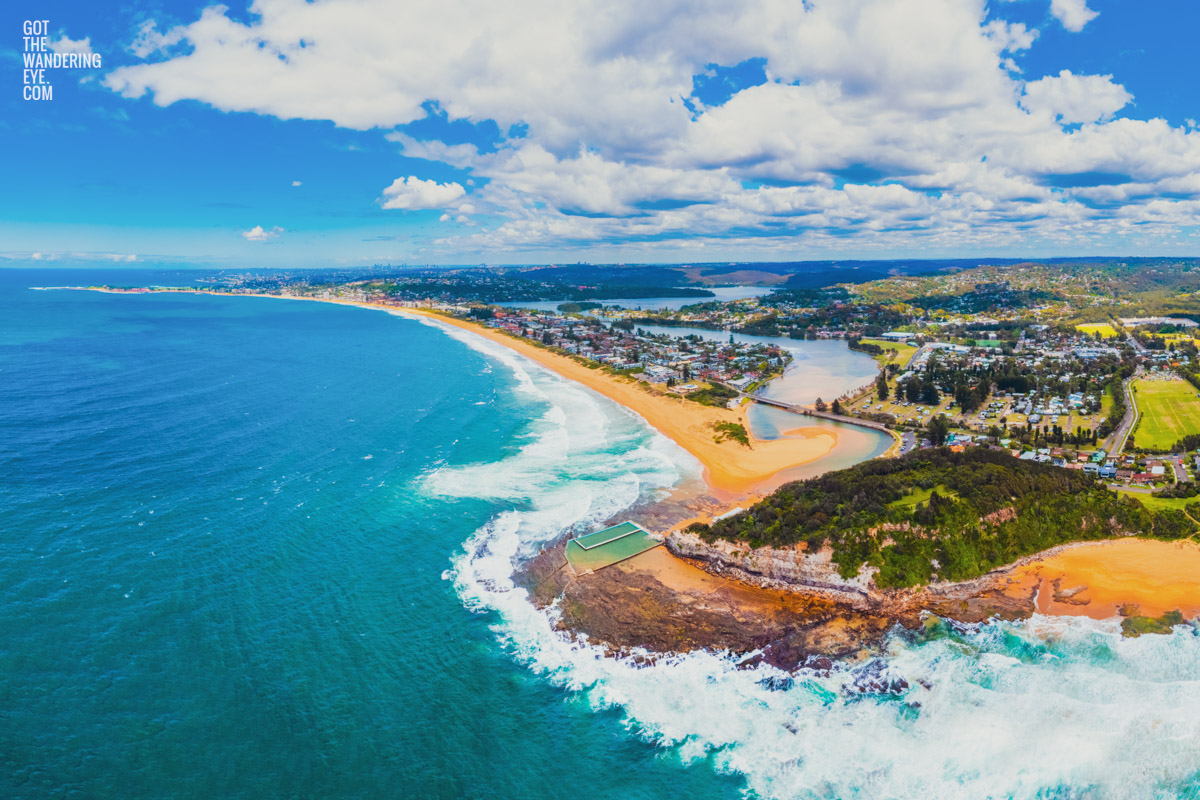 Aerial above North Narrabeen Beach rock ocean pool looking back to Manly.